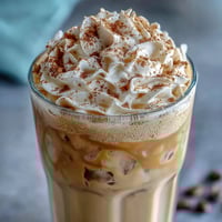Creamy vanilla bean frappuccino protein shake with whipped cream and a sprinkle of cinnamon, perfect for a quick, energizing treat.