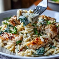 Lemon Orzo with Chicken and Spinach in a creamy skillet dish, garnished with fresh parsley and Parmesan.  